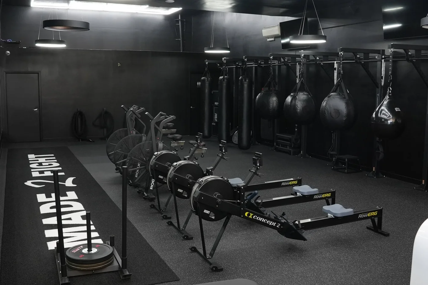 Heavy bags and rowing machines on the floor at Made 2 Fight, Long Beach